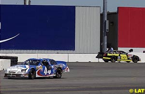 Winner Ricky Rudd races on in the background as Jerry Nadeau's broken car sits stationary in the foreground