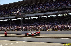 Helio Castroneves receives the chequered flag under yellow