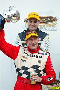 Mark Skaife holds the winner's trophy as Craig Lowndes looks on