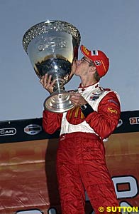 Sebastien Bourdais kisses the Vanderbilt Cup after taking the 2004 title